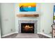 Inviting fireplace with light blue tile surround, wooden mantle, and beach-themed art at 2 Bridgewater Dr, Winter Haven, FL 33884
