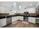 Bright kitchen features granite counters, stainless appliances, mosaic backsplash, and white cabinets at 2 Bridgewater Dr, Winter Haven, FL 33884
