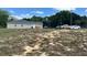 View of the back of the home showing a large yard and parked cars at 214 Brook Ln, Polk City, FL 33868