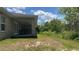 A view of the backyard, featuring lush landscaping and a covered patio at 214 Brook Ln, Polk City, FL 33868