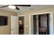 A bedroom featuring closet with wood organizers, neutral walls, white trim, and ceiling fan at 214 Brook Ln, Polk City, FL 33868