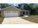 Inviting single-story home features a two-car garage, manicured lawn, and well-maintained landscaping at 214 Brook Ln, Polk City, FL 33868