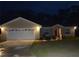 Charming single-story home featuring a two-car garage, inviting entrance, and landscaped front yard at 214 Brook Ln, Polk City, FL 33868