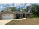 Charming single-story home featuring a two-car garage, well-maintained lawn, and delightful landscaping at 214 Brook Ln, Polk City, FL 33868