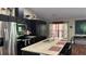 A bright kitchen featuring a large island with sink, stainless steel appliances, and dark wood cabinetry at 214 Brook Ln, Polk City, FL 33868