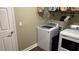 This laundry room features a washer and dryer with white cabinets, and shelving at 214 Brook Ln, Polk City, FL 33868