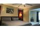 This main bedroom features an ceiling fan, neutral walls, red curtains, and a peacock painting above the bed at 214 Brook Ln, Polk City, FL 33868