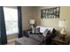 This living area features a dark colored couch with decorative pillows, accent tables, and a large window at 214 Brook Ln, Polk City, FL 33868
