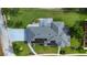 Bird's-eye view of a home with solar panels, a well-maintained yard, and a covered patio area at 217 Kent Ct, Haines City, FL 33844