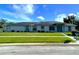 Inviting single-story home featuring a well-manicured lawn, bright facade, and attractive landscaping, and solar panels at 217 Kent Ct, Haines City, FL 33844
