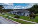 Inviting single-story home featuring a well-manicured lawn, bright facade, and attractive landscaping, and solar panels at 217 Kent Ct, Haines City, FL 33844