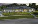 Well-maintained one-story home featuring a lush green lawn, tidy landscaping, and solar panels on the roof at 217 Kent Ct, Haines City, FL 33844