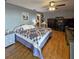 Comfortable main bedroom featuring blue accents, wood floors and ceiling fan at 218 Omaha St S S St, Lake Hamilton, FL 33851