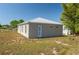 Back exterior of a modern home featuring durable siding and a metal roof, surrounded by a grassy lot at 225 Wes Mann Rd, Babson Park, FL 33827