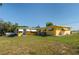 Yellow single-story home featuring white awnings, a blue front door, and a well-maintained lawn at 225 Wes Mann Rd, Babson Park, FL 33827