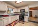 Charming kitchen with white cabinets, black appliances, tile floors, and great natural light at 225 Wes Mann Rd, Babson Park, FL 33827