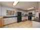 Well-lit kitchen featuring tile flooring, light cabinets, modern appliances, and a skylight at 225 Wes Mann Rd, Babson Park, FL 33827