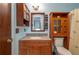 Traditional bathroom design featuring a granite vanity, wooden cabinets, and matching wooden mirror at 23 Kendra Ct, Winter Haven, FL 33880