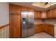 This kitchen has stainless steel refrigerator and wooden cabinets at 23 Kendra Ct, Winter Haven, FL 33880