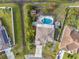 Aerial view of a home with a screened pool, small shed, and a traditional concrete driveway at 247 Cobalt Dr, Kissimmee, FL 34758