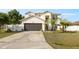Charming two-story home featuring a two-car garage and a well-manicured lawn with palm trees at 247 Cobalt Dr, Kissimmee, FL 34758