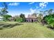 Expansive backyard view showcasing lush green grass and mature trees at 2750 W Lake Hamilton Dr, Winter Haven, FL 33881