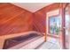 Luxurious bathroom featuring a large tub, tile flooring, and walls with wood paneling at 2750 W Lake Hamilton Dr, Winter Haven, FL 33881