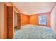 This orange bedroom has wooden wall paneling, neutral carpet and a window at 2750 W Lake Hamilton Dr, Winter Haven, FL 33881