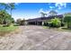 Wide driveway leading to a covered carport, surrounded by mature trees and landscaping, offering ample parking and curb appeal at 2750 W Lake Hamilton Dr, Winter Haven, FL 33881