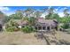 Single-story home featuring large windows and lush tropical landscaping, creating a private, tranquil setting at 2750 W Lake Hamilton Dr, Winter Haven, FL 33881
