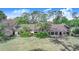Expansive single-story home featuring large windows and mature tropical landscaping, perfect for enjoying the serene surroundings at 2750 W Lake Hamilton Dr, Winter Haven, FL 33881