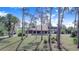 View of the house with a large carport featuring stone columns, framed by trees at 2750 W Lake Hamilton Dr, Winter Haven, FL 33881