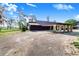 The house with a carport featuring stone columns with a cracked driveway and ample green space at 2750 W Lake Hamilton Dr, Winter Haven, FL 33881