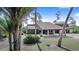 Unique home featuring a carport with stone columns and a spacious driveway surrounded by mature trees at 2750 W Lake Hamilton Dr, Winter Haven, FL 33881