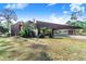 Unique home featuring wood siding, angular roofline, lush tropical plants, and a covered carport, creating a distinctive modern aesthetic at 2750 W Lake Hamilton Dr, Winter Haven, FL 33881