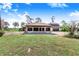 Expansive front lawn and unique home featuring a carport with stone columns at 2750 W Lake Hamilton Dr, Winter Haven, FL 33881