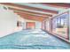 Bright living room featuring exposed beams, large windows, and a sliding glass door, offering ample natural light and indoor-outdoor flow at 2750 W Lake Hamilton Dr, Winter Haven, FL 33881