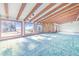 Expansive living room with exposed beams, stone accents, and large windows, creating a bright and airy space with scenic views at 2750 W Lake Hamilton Dr, Winter Haven, FL 33881