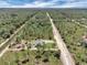 Overhead view displaying the home surrounded by wooded area and a lengthy driveway at 3120 Oleander Dr, Indian Lake Estates, FL 33855