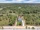 Aerial view showcasing the house nestled among a lot of trees with a long driveway at 3120 Oleander Dr, Indian Lake Estates, FL 33855