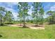 Expansive backyard with lush greenery and mature trees providing ample shade at 3120 Oleander Dr, Indian Lake Estates, FL 33855