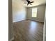 Clean bedroom with wood-look flooring, neutral paint, and ample natural light from the window at 3120 Oleander Dr, Indian Lake Estates, FL 33855