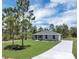 Inviting single-story home featuring a spacious front lawn, classic gray exterior, and concrete driveway at 3120 Oleander Dr, Indian Lake Estates, FL 33855