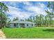 Charming single-story home featuring a well-manicured lawn, fresh landscaping, and a inviting exterior at 3120 Oleander Dr, Indian Lake Estates, FL 33855