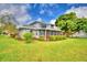 Expansive lawn surrounds this elegant home, complemented by mature trees and lush landscaping at 329 Hamilton Shores Ne Dr, Winter Haven, FL 33881