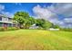 This spacious backyard is a green haven with its lush lawn and mature trees, with a view of the pond at 329 Hamilton Shores Ne Dr, Winter Haven, FL 33881