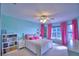 A bright bedroom features colorful curtains and a decorative bookshelf, creating a cozy and inviting space at 329 Hamilton Shores Ne Dr, Winter Haven, FL 33881