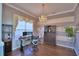 Bright home office with chandelier, stylish striped walls, and modern desk setup at 329 Hamilton Shores Ne Dr, Winter Haven, FL 33881