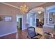 Bright home office featuring elegant columns, modern chandelier, and views into the living room at 329 Hamilton Shores Ne Dr, Winter Haven, FL 33881