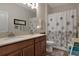 Bathroom features a double vanity with countertop, and a shower/tub combo with decorative curtain at 3710 Plymouth Dr, Winter Haven, FL 33884